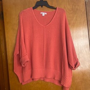 A slightly orange sweater with 3/4 sleeve size Xl